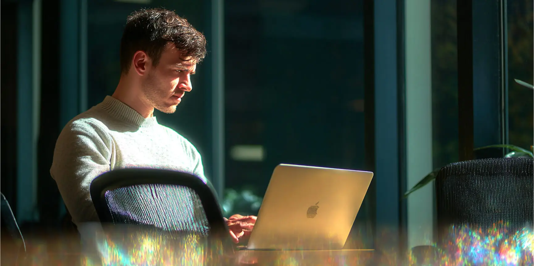 Man working on laptop in bright office