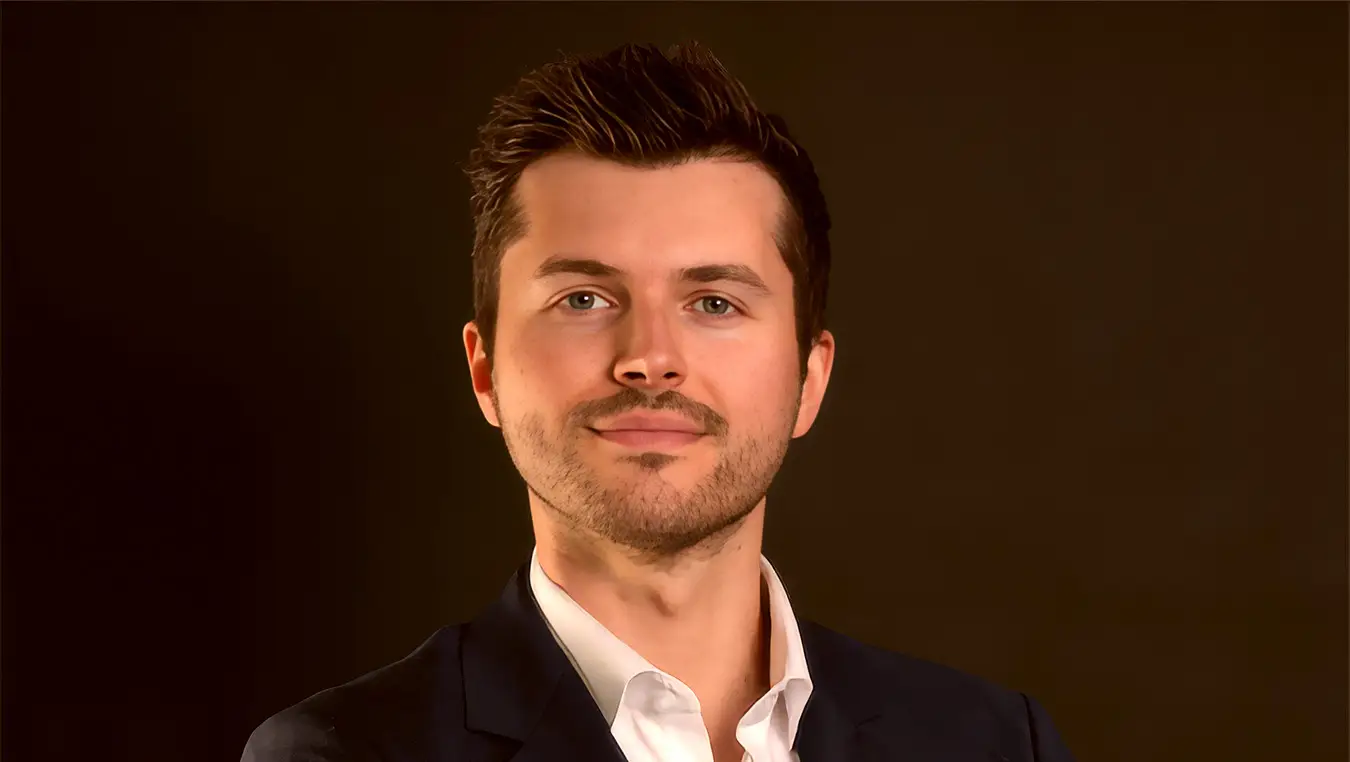 Man in suit posing against dark background